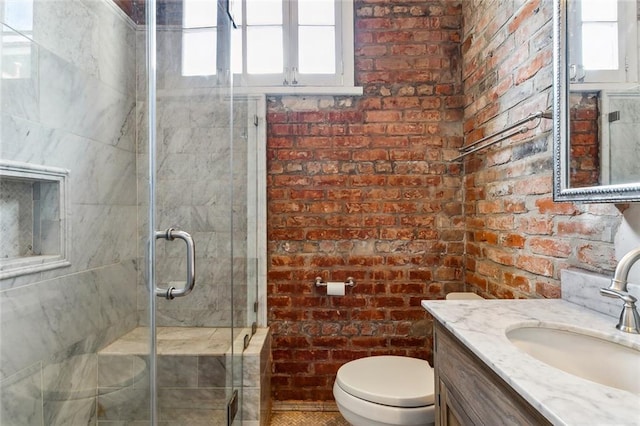 bathroom featuring a wealth of natural light, brick wall, and toilet