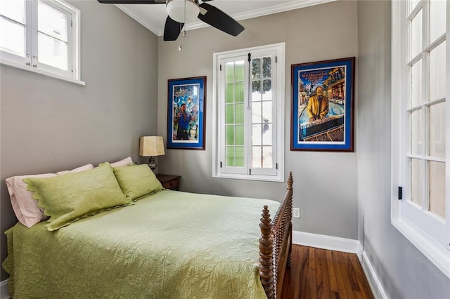 bedroom featuring ornamental molding, multiple windows, wood-type flooring, and ceiling fan