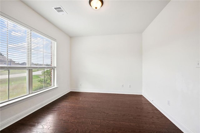 unfurnished room with dark wood-type flooring and a healthy amount of sunlight