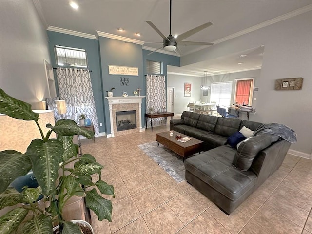 tiled living room featuring ceiling fan, a tile fireplace, and ornamental molding