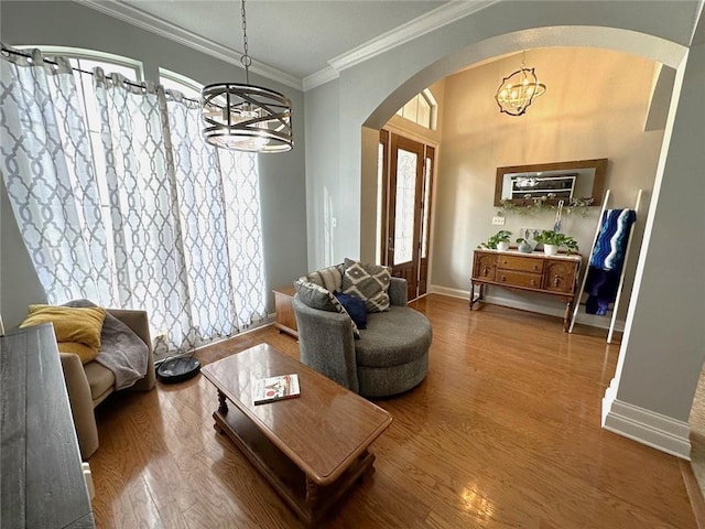 living room featuring a chandelier, wood-type flooring, and ornamental molding