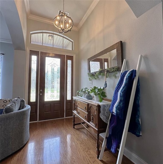 entrance foyer featuring hardwood / wood-style flooring, a chandelier, and ornamental molding