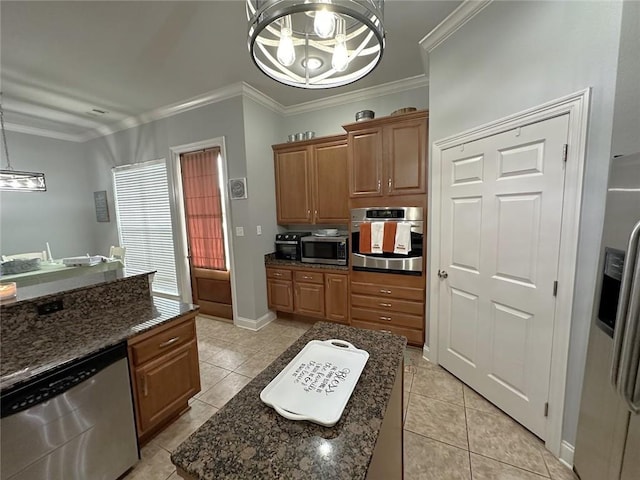 kitchen featuring appliances with stainless steel finishes, light tile patterned floors, decorative light fixtures, crown molding, and a center island