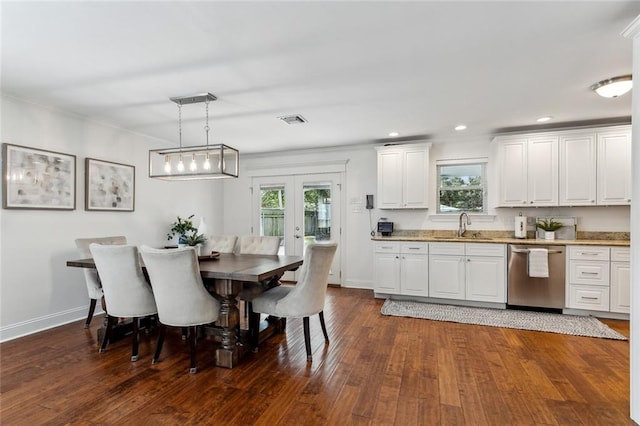 dining area with a wealth of natural light, dark hardwood / wood-style floors, sink, and french doors