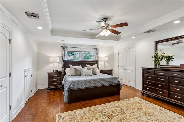 bedroom featuring ornamental molding, dark wood-type flooring, ceiling fan, and a raised ceiling