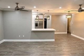 kitchen featuring stainless steel fridge, ceiling fan, dark hardwood / wood-style floors, white cabinetry, and hanging light fixtures