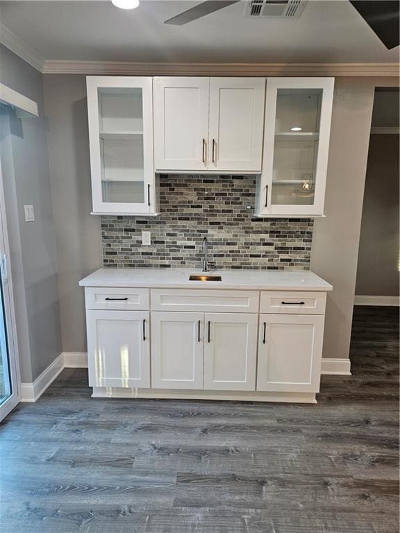 kitchen featuring white cabinets, dark hardwood / wood-style flooring, and backsplash