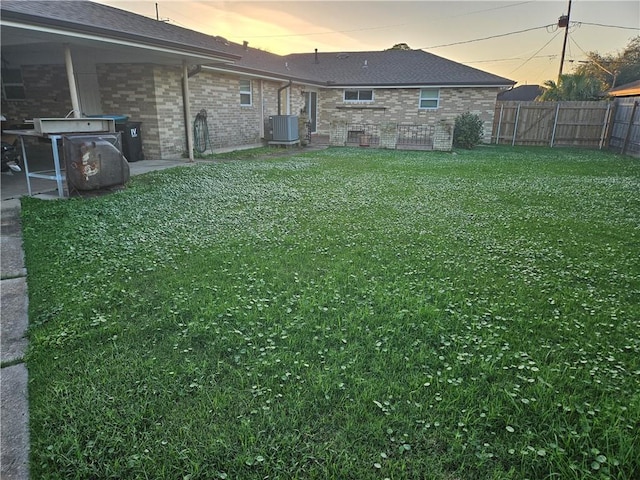 yard at dusk featuring central air condition unit