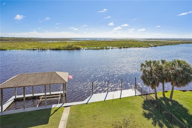 dock area with a water view and a yard