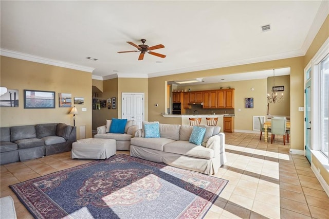 tiled living room with ceiling fan with notable chandelier and crown molding