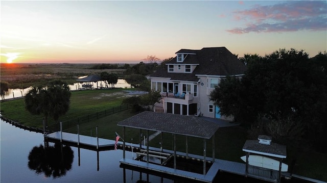 back house at dusk featuring a water view