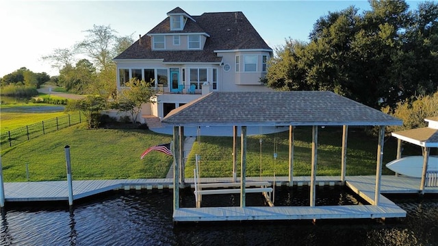 back of house featuring a water view and a yard