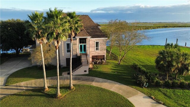 view of front of property with a water view and a front lawn