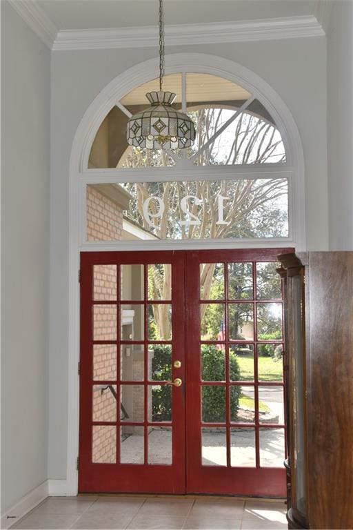 doorway to outside featuring light tile patterned floors, baseboards, ornamental molding, french doors, and a chandelier