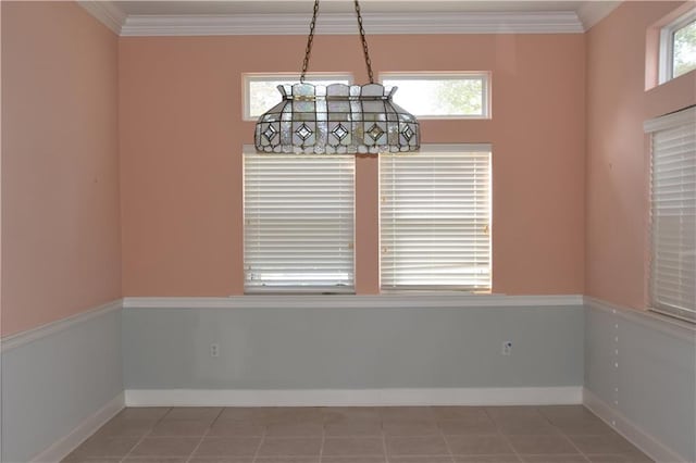 empty room featuring tile patterned floors and crown molding