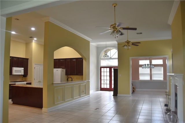 kitchen with white appliances, visible vents, a towering ceiling, light countertops, and crown molding