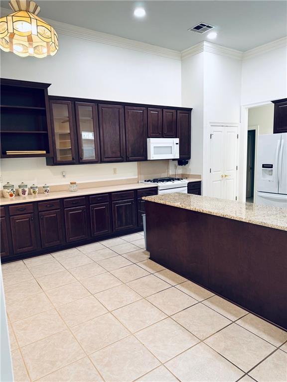 kitchen featuring light tile patterned floors, white appliances, visible vents, open shelves, and crown molding