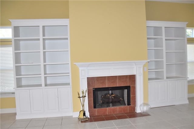 unfurnished living room featuring light tile patterned floors, baseboards, and a tile fireplace