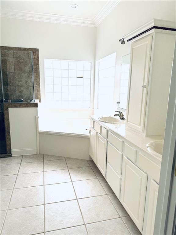 bathroom with double vanity, a garden tub, tile patterned flooring, crown molding, and a sink