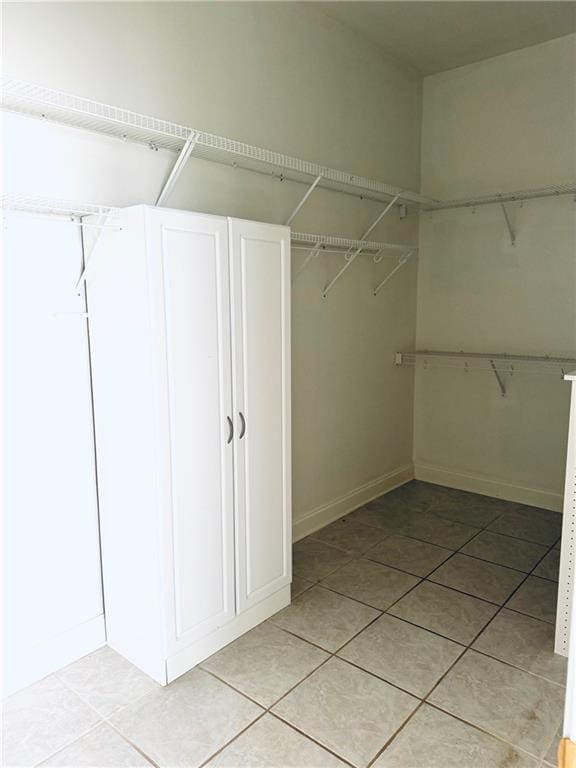 spacious closet featuring light tile patterned floors