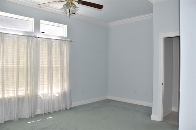 spare room with ceiling fan, baseboards, crown molding, and carpet flooring