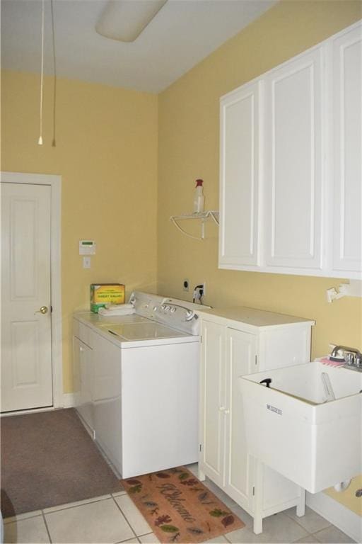 laundry area with cabinet space, a sink, washer and clothes dryer, and light tile patterned floors