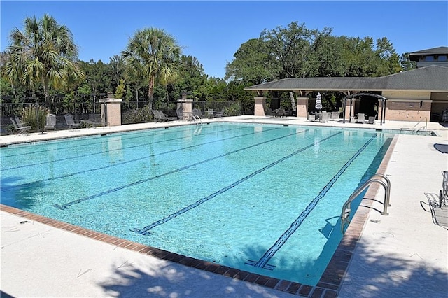 community pool featuring a patio and fence