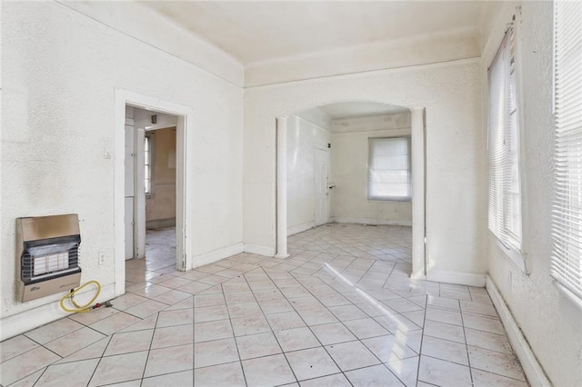 empty room with heating unit and light tile patterned flooring