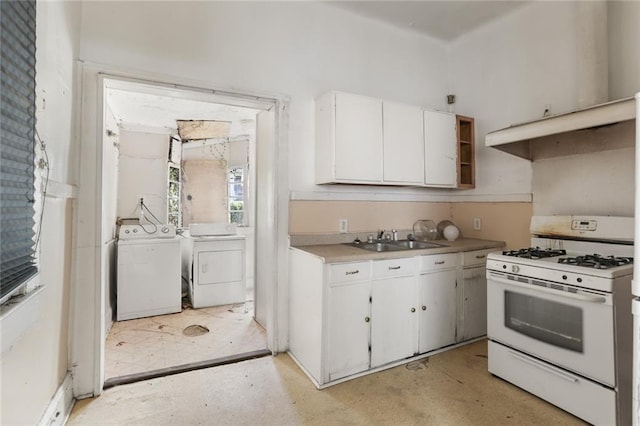 kitchen featuring white cabinets, separate washer and dryer, sink, and white gas stove