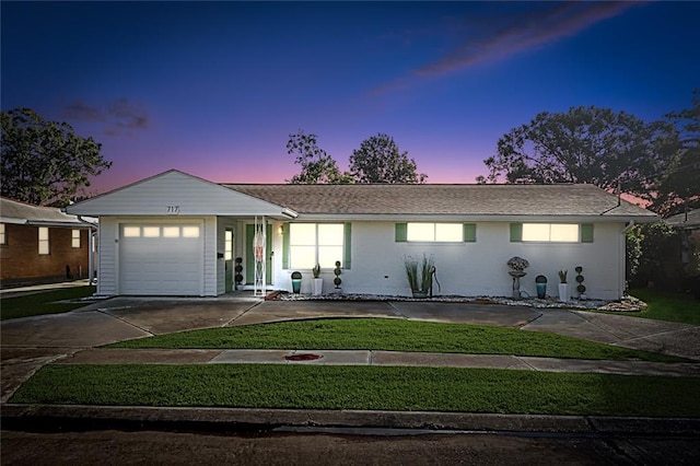 ranch-style house featuring a lawn and a garage