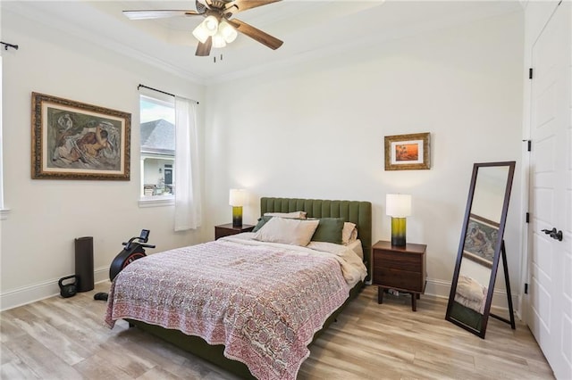 bedroom with ceiling fan, light wood-type flooring, and crown molding