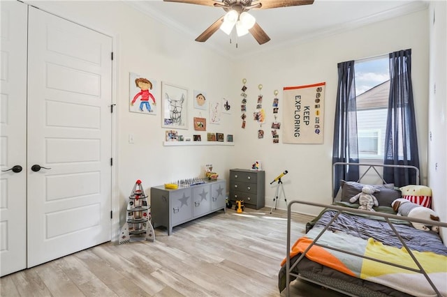 bedroom featuring ornamental molding, ceiling fan, and light hardwood / wood-style flooring