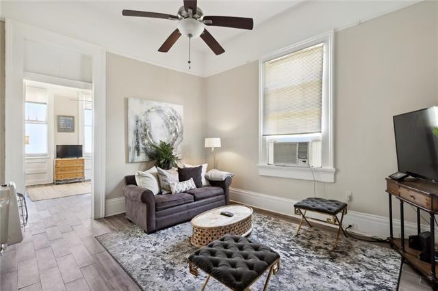 living room with ceiling fan, cooling unit, and light hardwood / wood-style floors