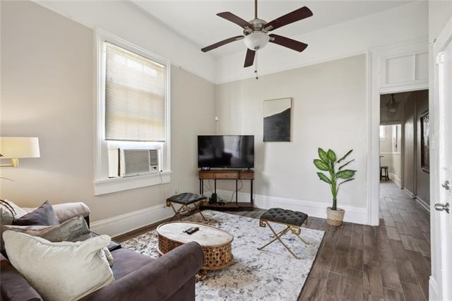 living room featuring cooling unit, dark wood-type flooring, and ceiling fan