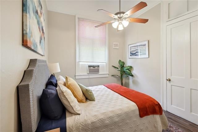 bedroom featuring hardwood / wood-style flooring, ceiling fan, and cooling unit