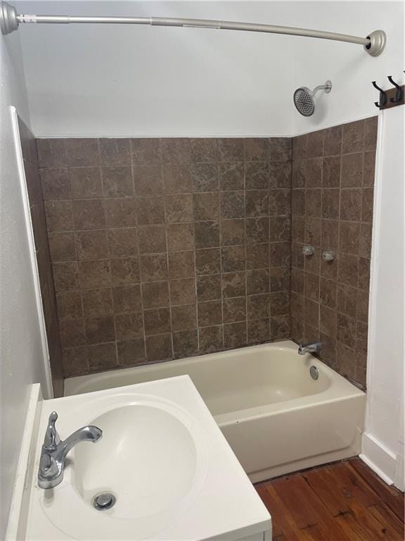 bathroom featuring wood-type flooring, sink, and tiled shower / bath