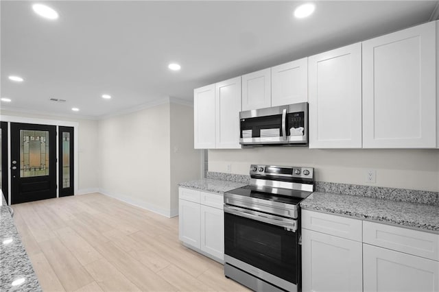 kitchen featuring stainless steel appliances, light hardwood / wood-style floors, light stone counters, ornamental molding, and white cabinets