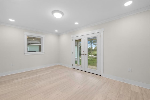 spare room featuring light wood-type flooring, french doors, and ornamental molding