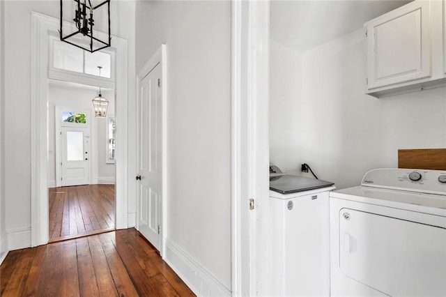 clothes washing area featuring dark hardwood / wood-style flooring, cabinets, independent washer and dryer, and a notable chandelier