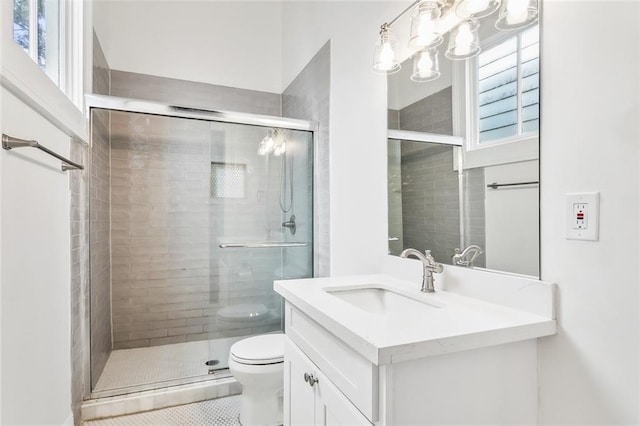 bathroom featuring vanity, walk in shower, a healthy amount of sunlight, and toilet