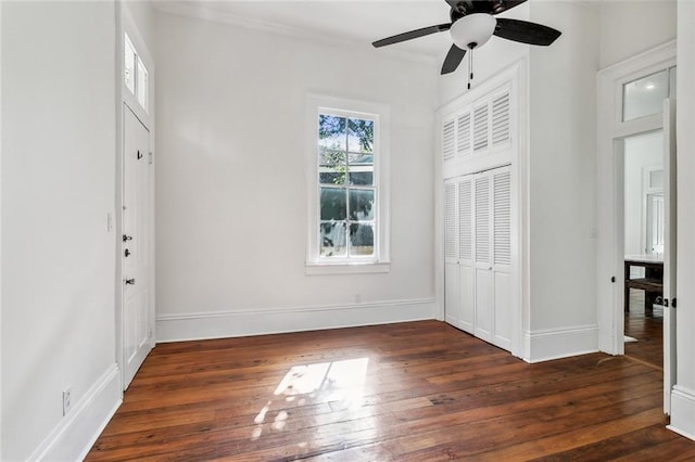 unfurnished bedroom with dark hardwood / wood-style flooring, a closet, and ceiling fan