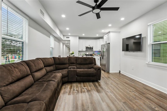 living room featuring light hardwood / wood-style floors and ceiling fan