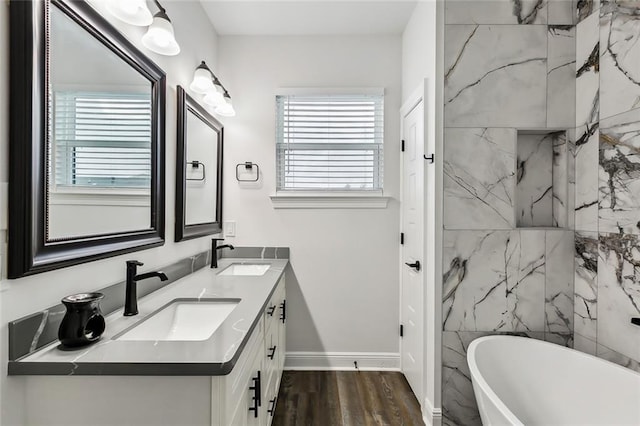 bathroom featuring hardwood / wood-style floors, vanity, and a tub