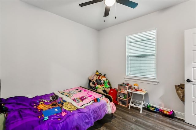 bedroom featuring baseboards, wood finished floors, and a ceiling fan