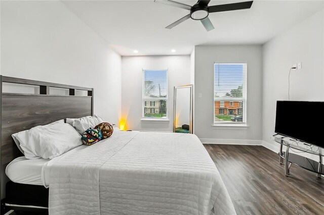 bedroom with dark hardwood / wood-style flooring and ceiling fan