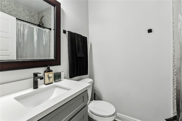 full bath featuring a shower with shower curtain, toilet, and vanity