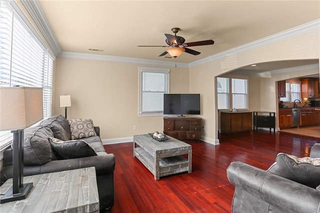 living room featuring dark hardwood / wood-style floors, ceiling fan, sink, and crown molding