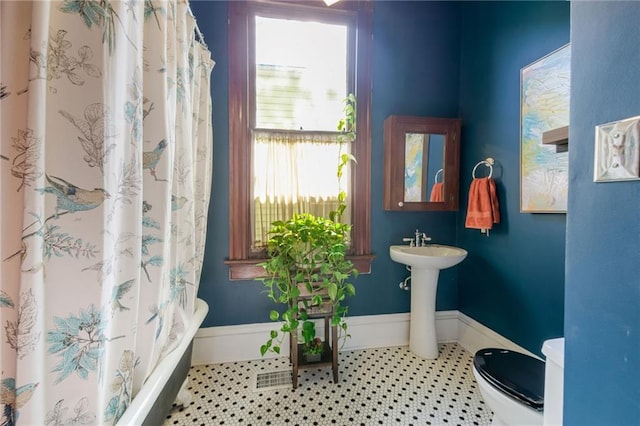 bathroom with walk in shower, tile patterned flooring, and toilet