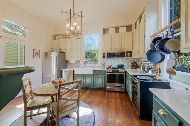 kitchen featuring stainless steel appliances, dark wood-type flooring, sink, and backsplash