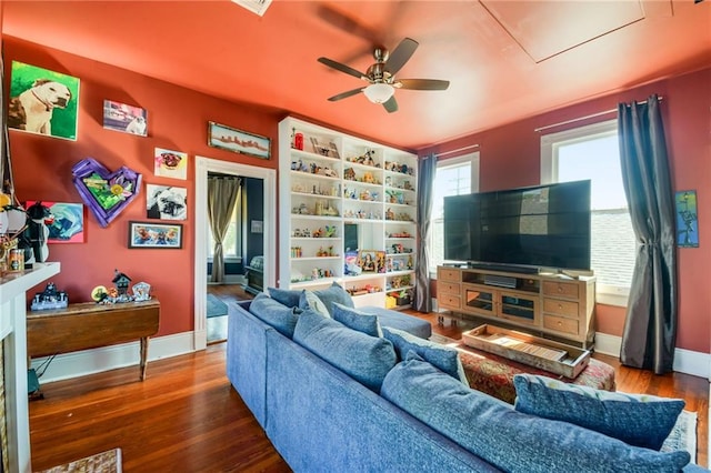 living room featuring dark wood-type flooring and ceiling fan